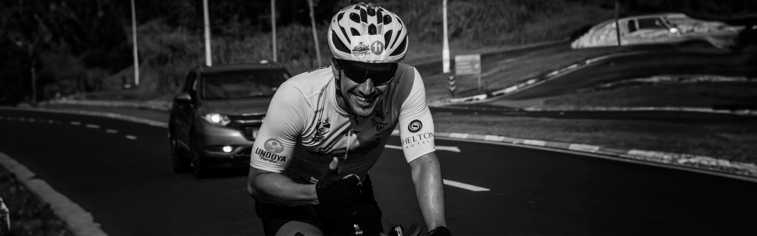 atleta ciclismo pedalando, sorrindo e fazendo sinal de positivo