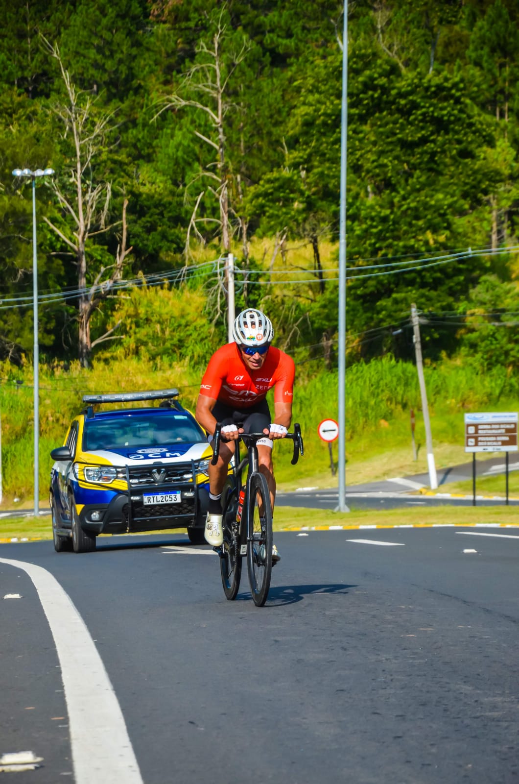 atleta de ciclismo com policia na rodovia